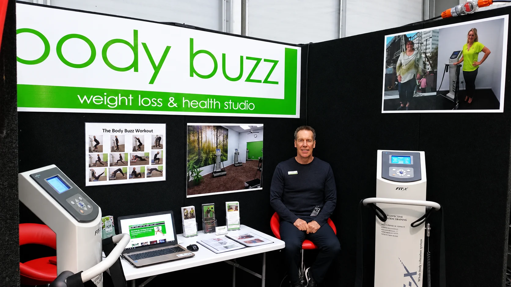 Marty seated at a Body Buzz display with vibration-training equipment